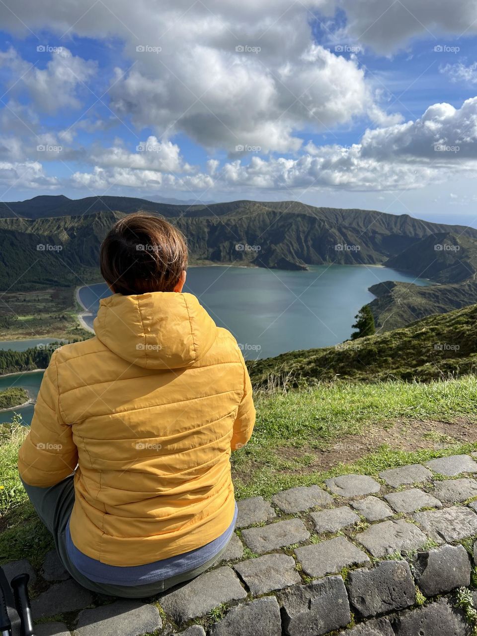 Woman with yellow jacket looking panoramic lake view 