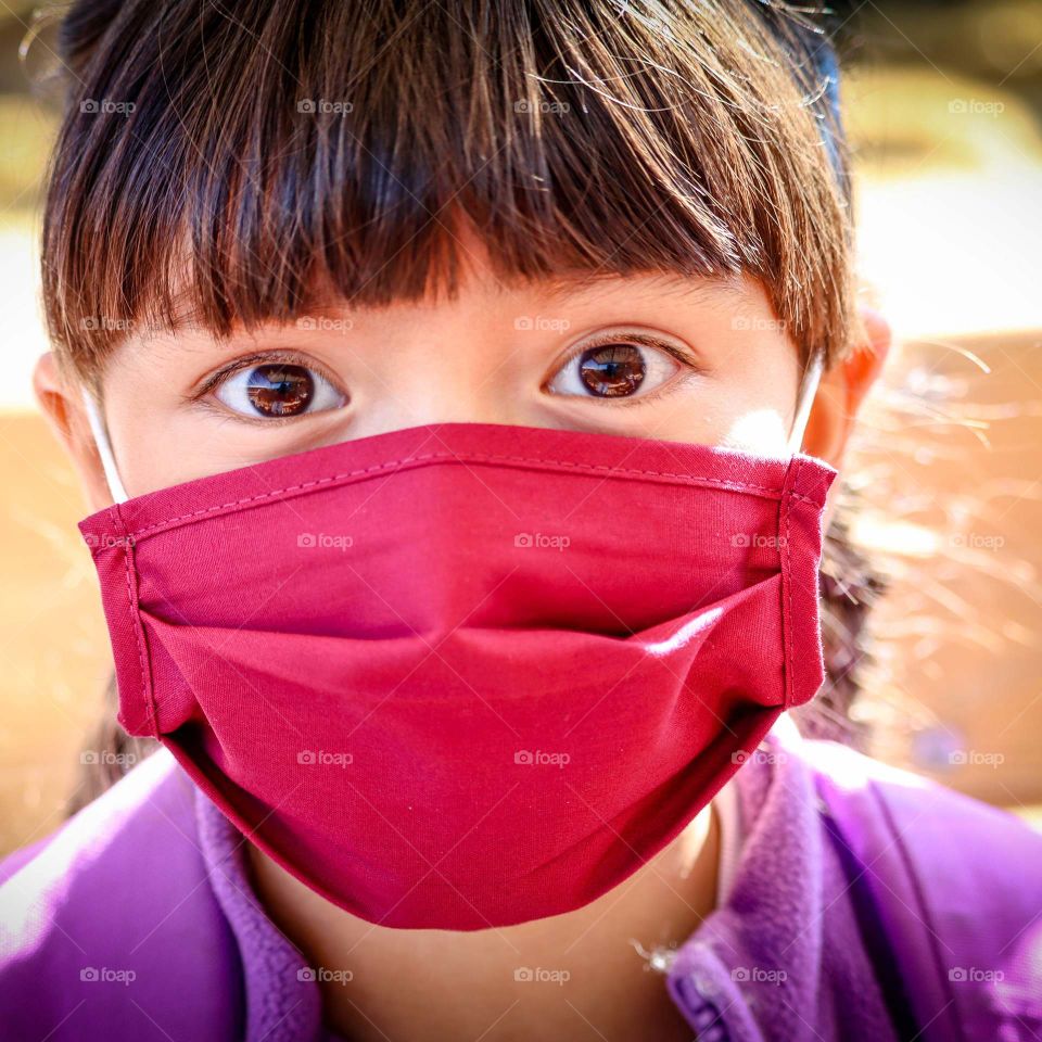 Little girl in a red face mask