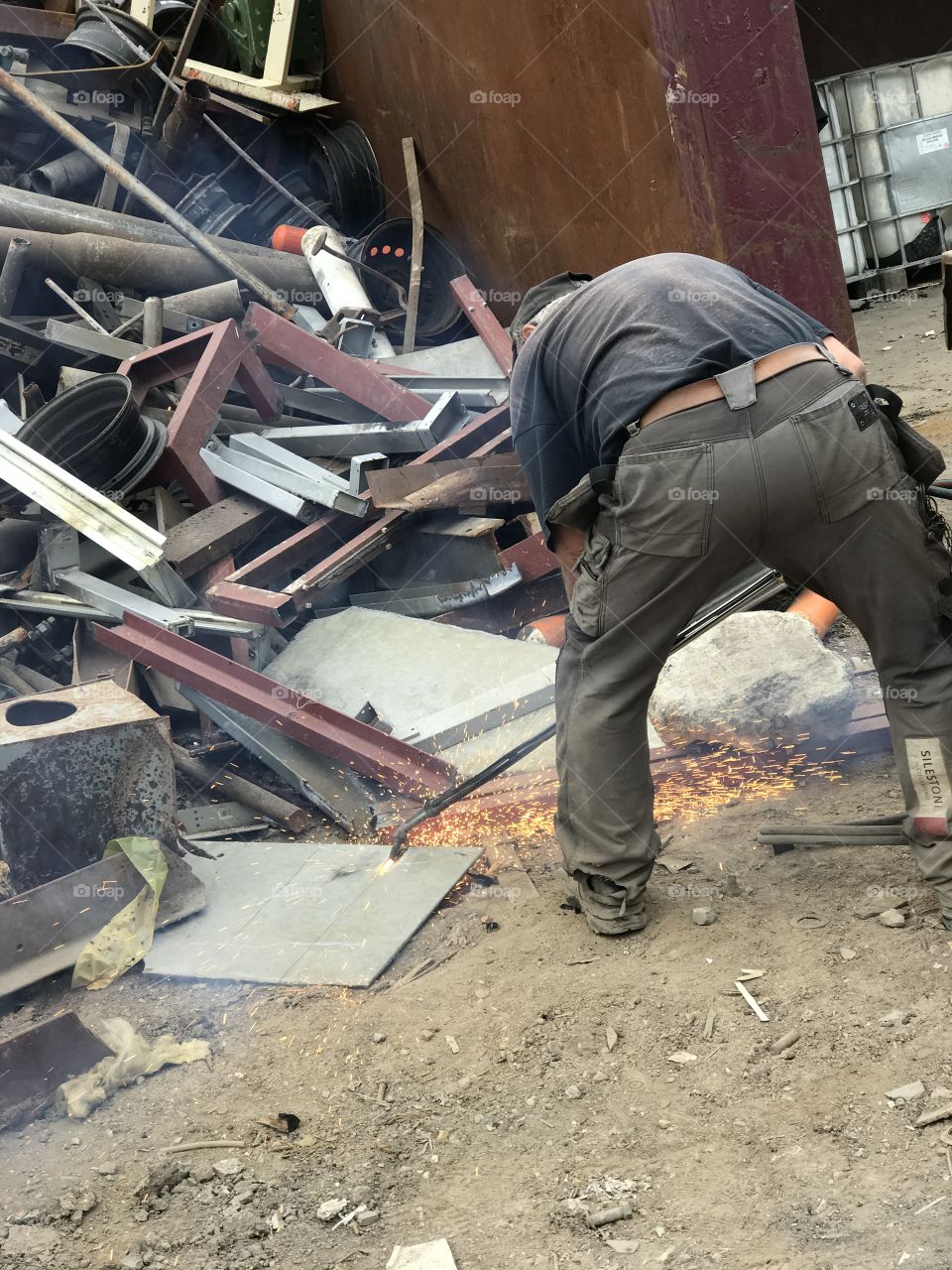 Blowtorching metal at scrap yard