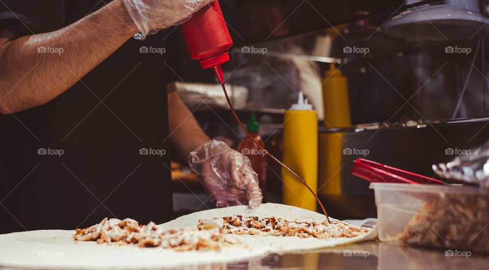cooking fast food, cook chef agitates a meat dish with ketchup