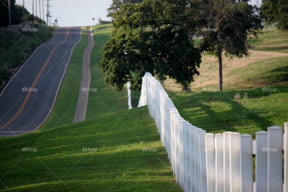 Country white fence and road