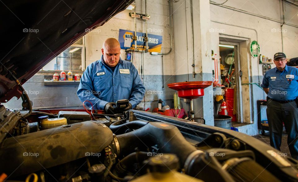 Car mechanic checking on engine