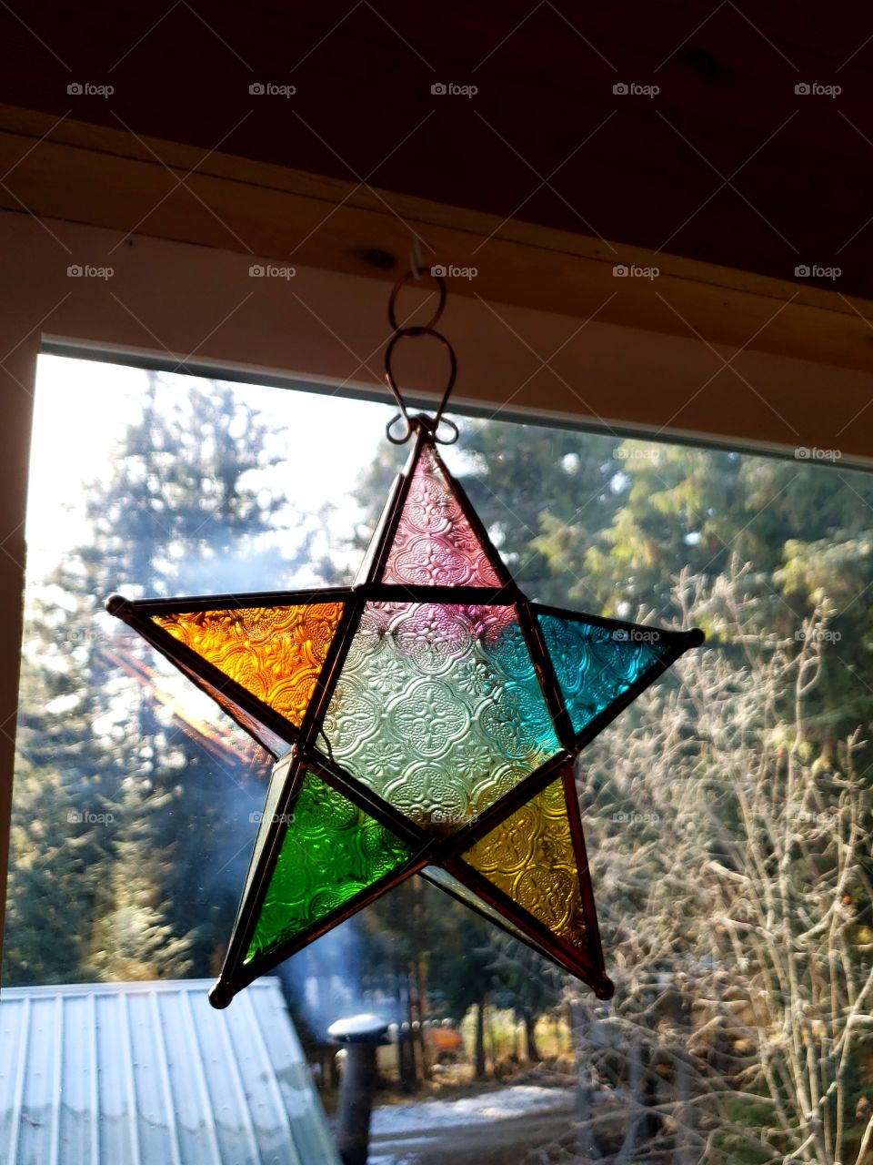 star sun catcher in window scenic forrest view