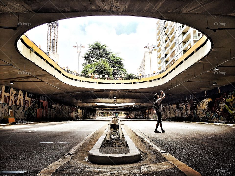 Man photographs in illuminated tunnel I city streets 