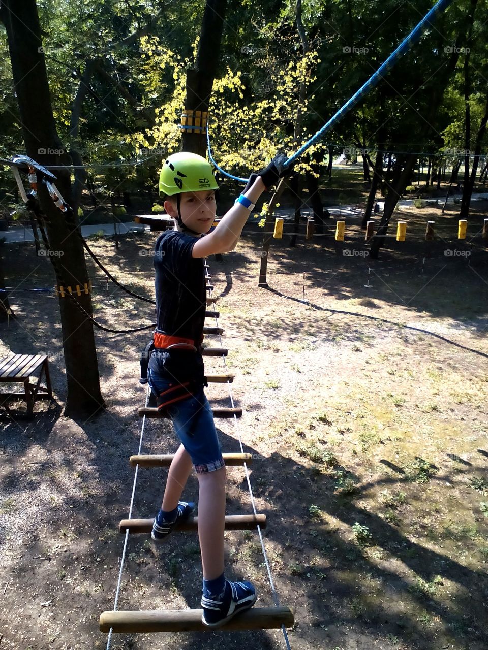 Equilibrist. Tightrope walker. I like to climb the ropes. Conquering new heights. Extreme hobby. On day of life. Last warm days. Positive emotions. Rope park. Brave. Fearless. Sports. On high.