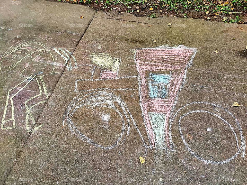 Children's drawing with crayons on the asphalt.  The carriage and the monster