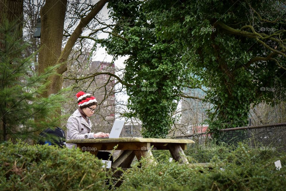Girl  in a park working at the labtop