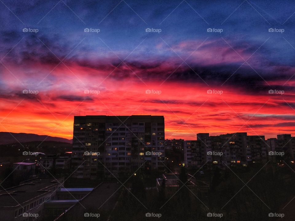 A picturesque scenery of the sunset clouds in amazing colours like orange, red, purple and pink with the apartment buildings beneath in the capital of Bulgaria