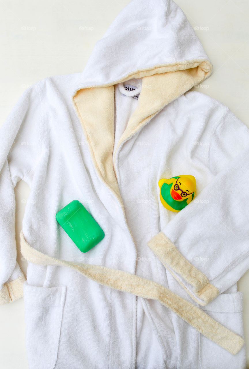 Child's bathrobe laid out with soap and a rubber duck
