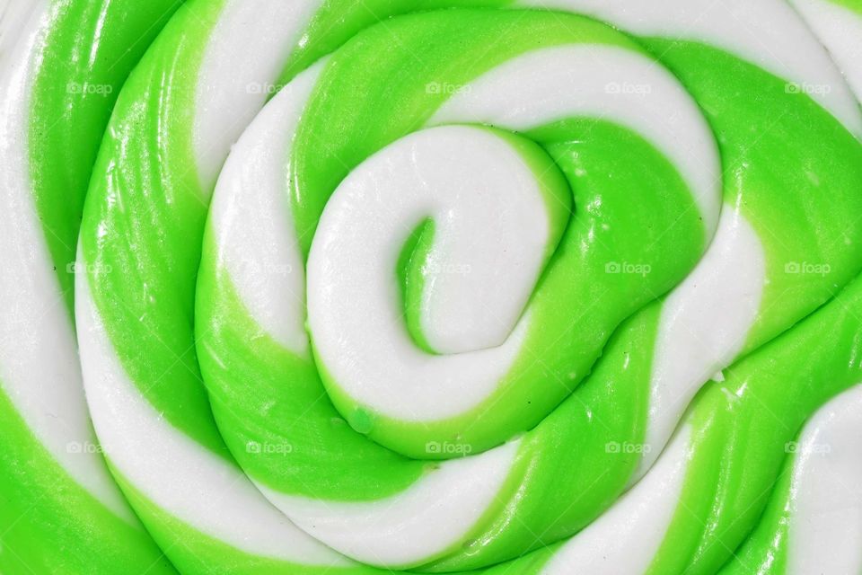 Foap mission Sugar: Close up photo of a large green and white swirled lollipop. 