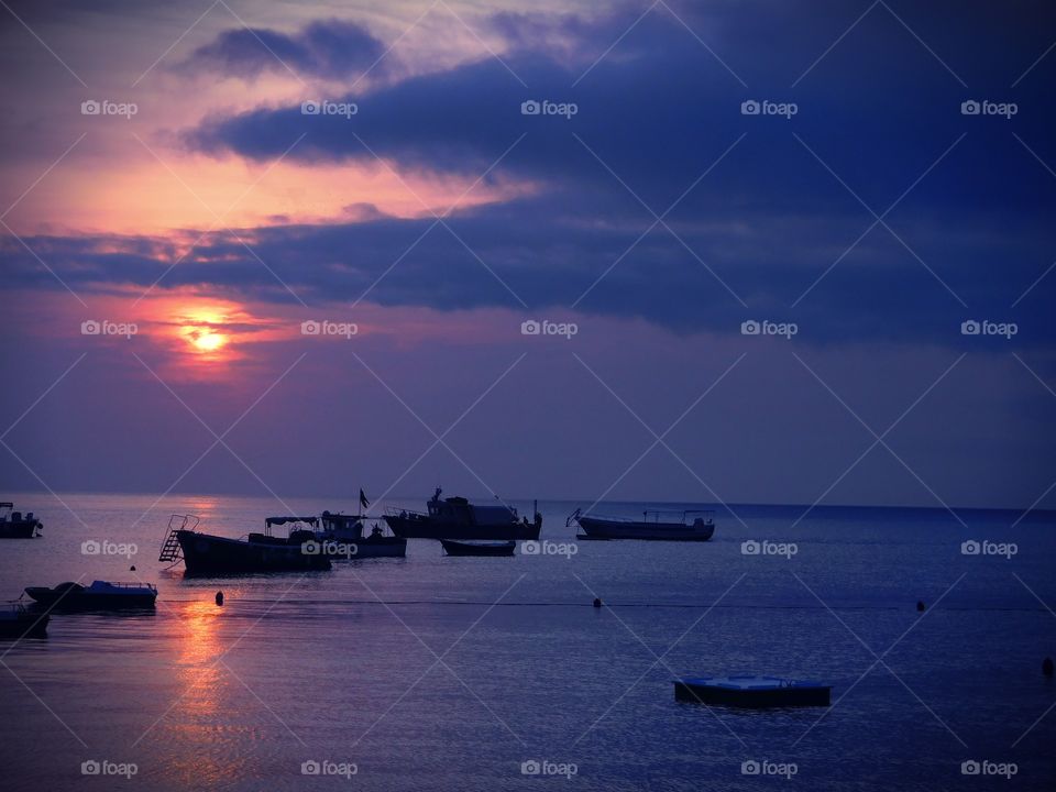 Sun is obscured by pink clouds.  Praia ( Italy ).