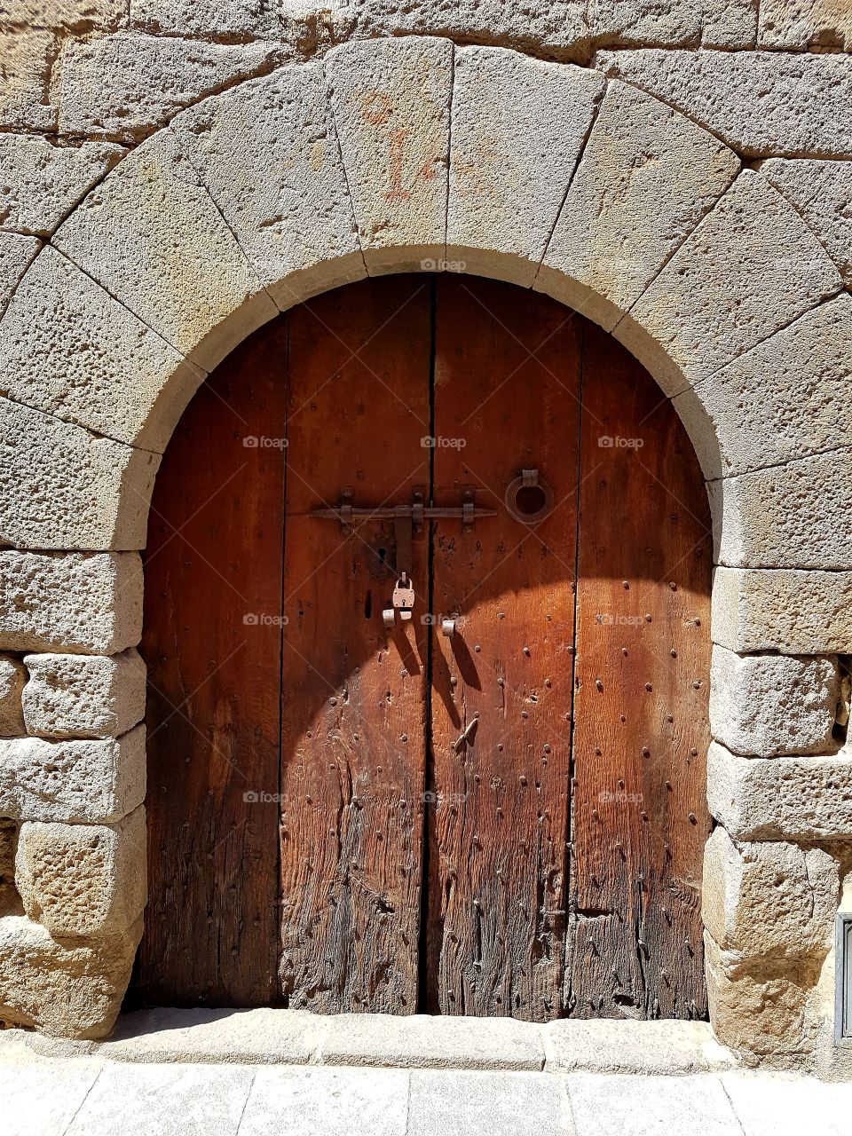 old wooden door with a stone frame at Castelló d'Ampurias, Catalonia