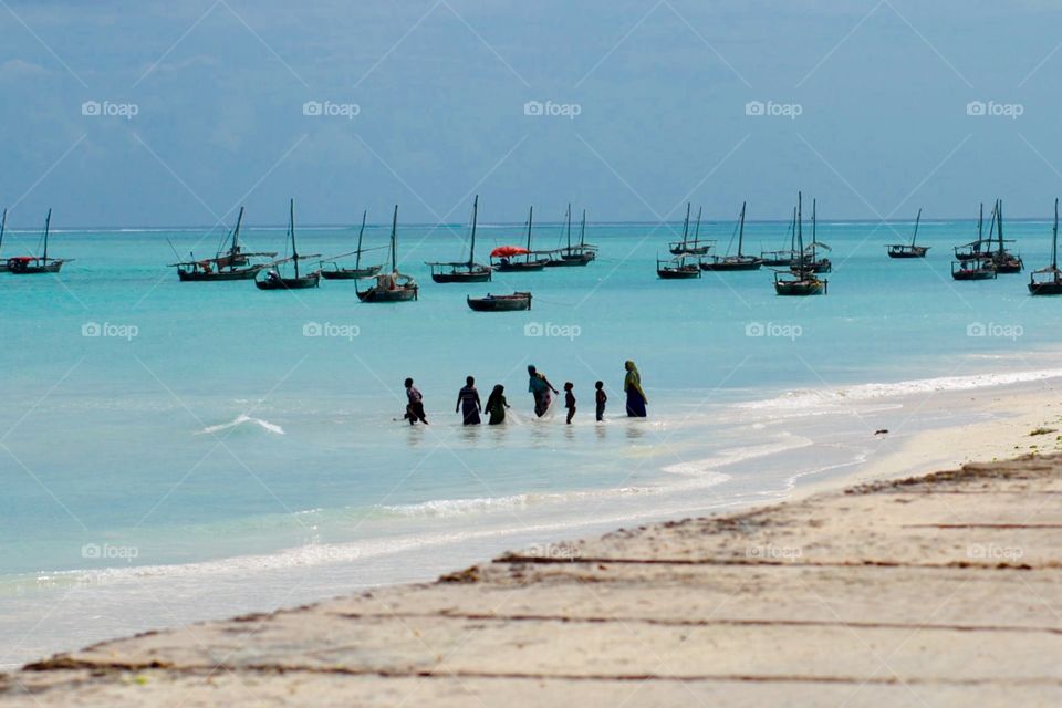 Silhouette people in the sea. Fishing family on Zanzibar Island Tanzania