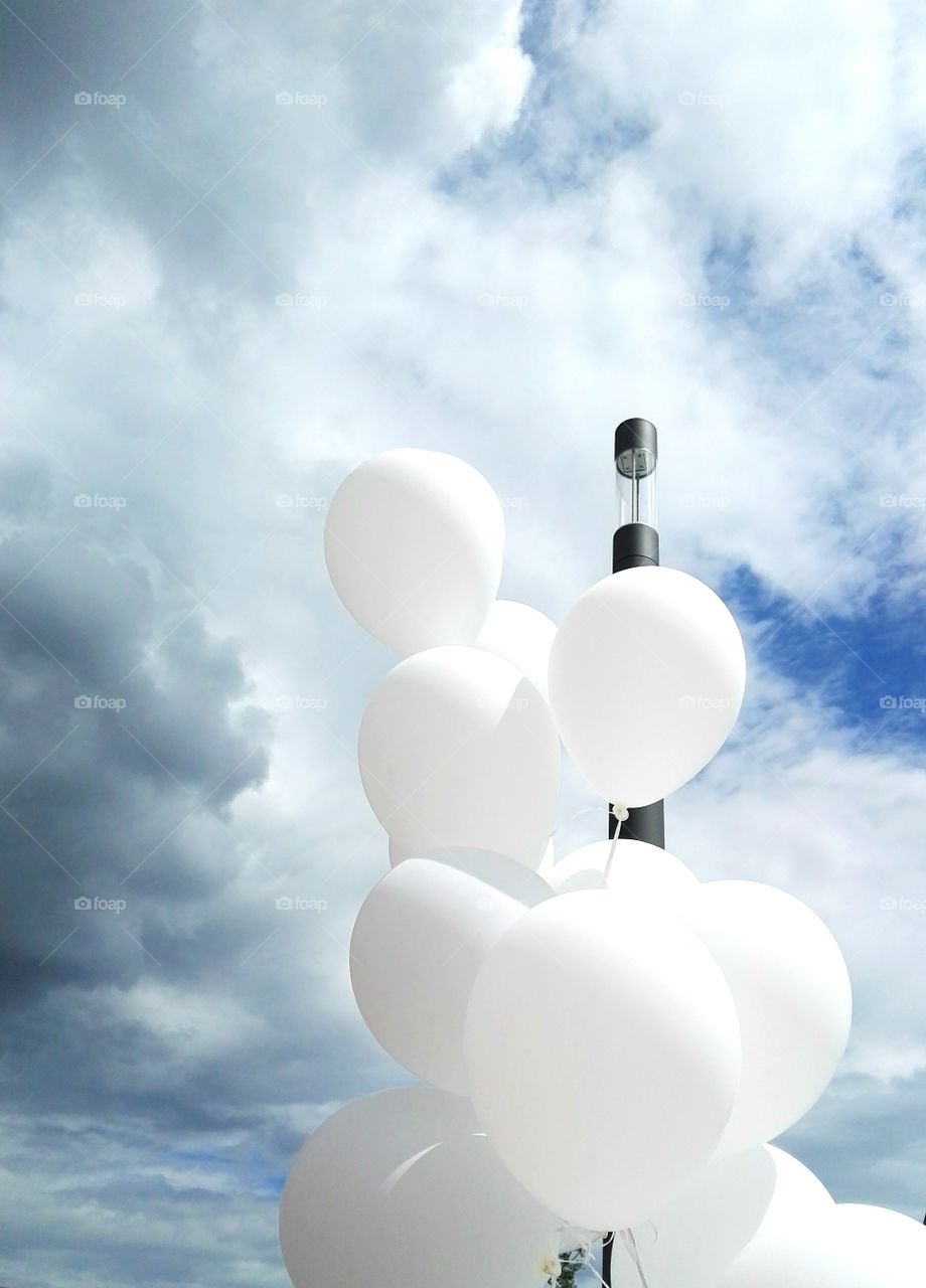 White balloons on the background of a summer stormy sky