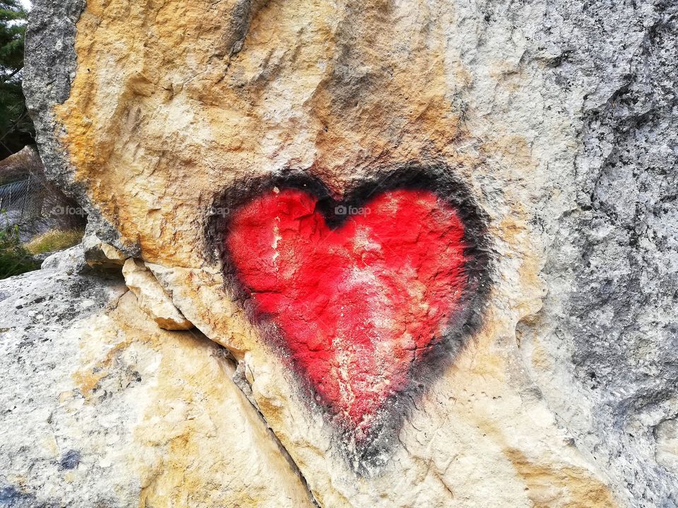 Red heart painted on a rock