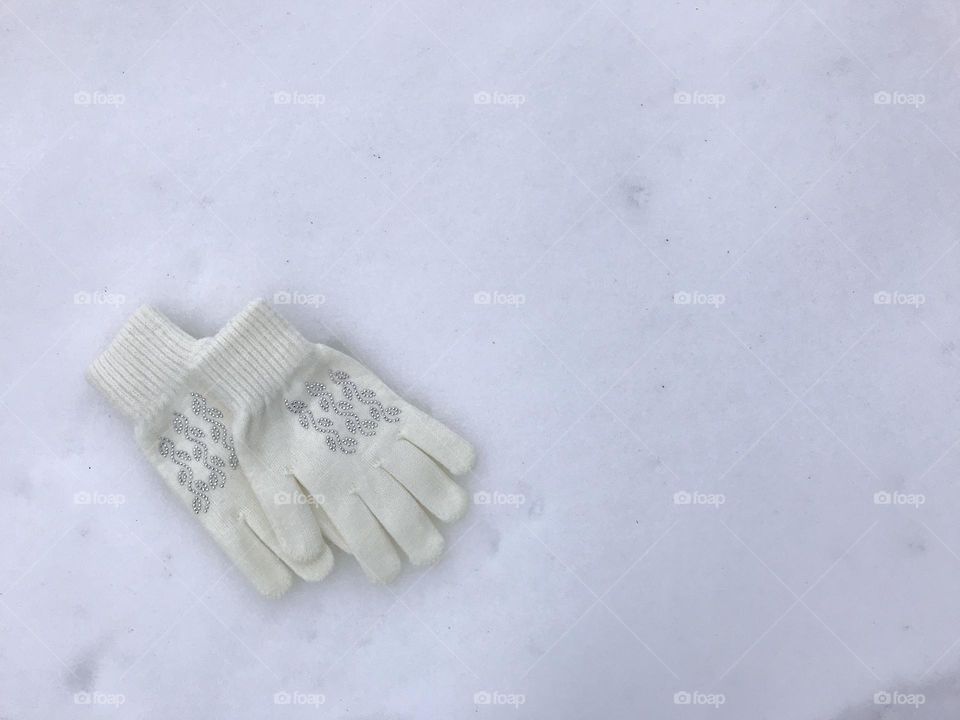 Two white gloves in the snow