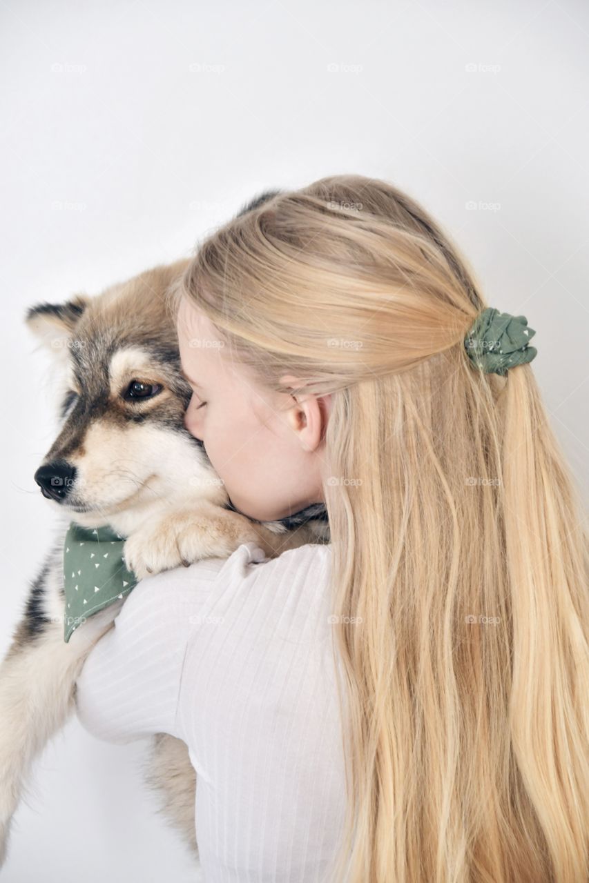 Photo of a woman holding a young puppy finnish lapphund dog wearing matching bandana and scrunchie