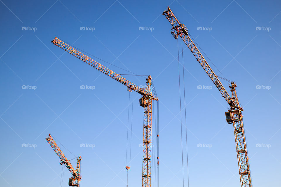 construction cranes against a blue sky