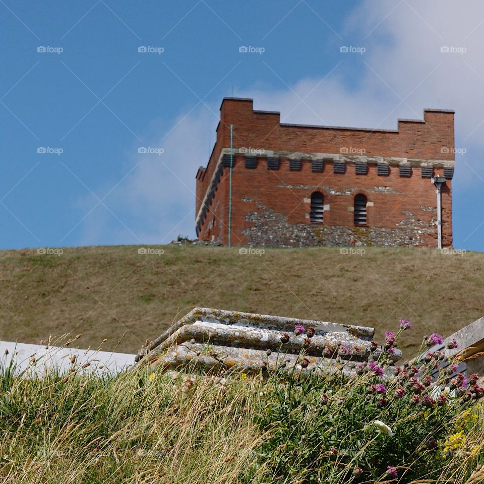 An old brick fortified building on a hill in England on a sunny summer day. 