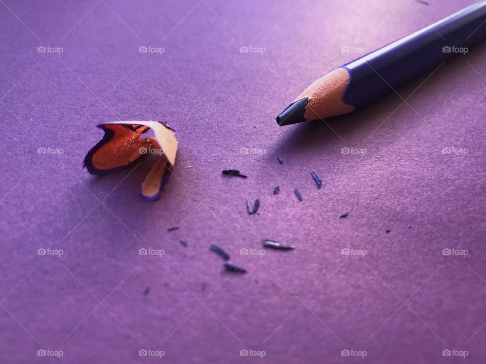 Purple pencil and shavings on purple background