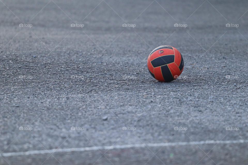 A ball on the basketball court with nobody around it 