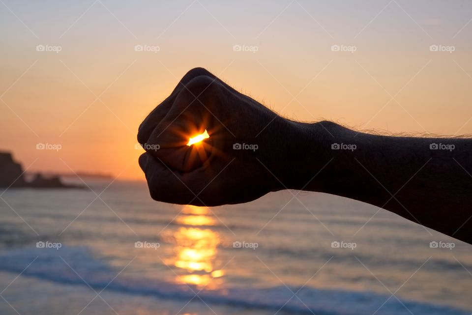 Catching the sun by hand at sunset