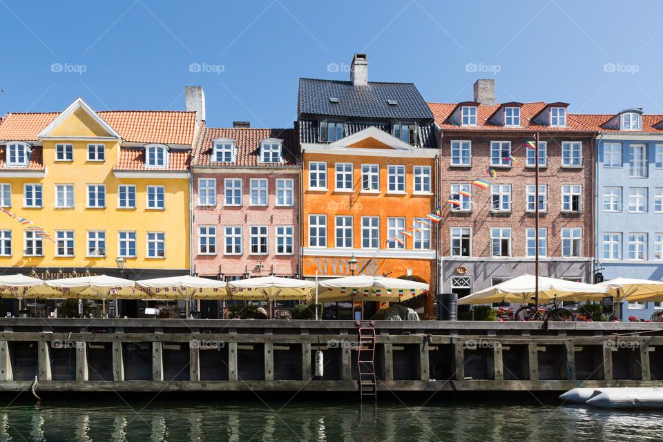 Beautiful colorful houses, architecture by the water in Nyhavn Copenhagen Denmark on a sunny day with blue sky 