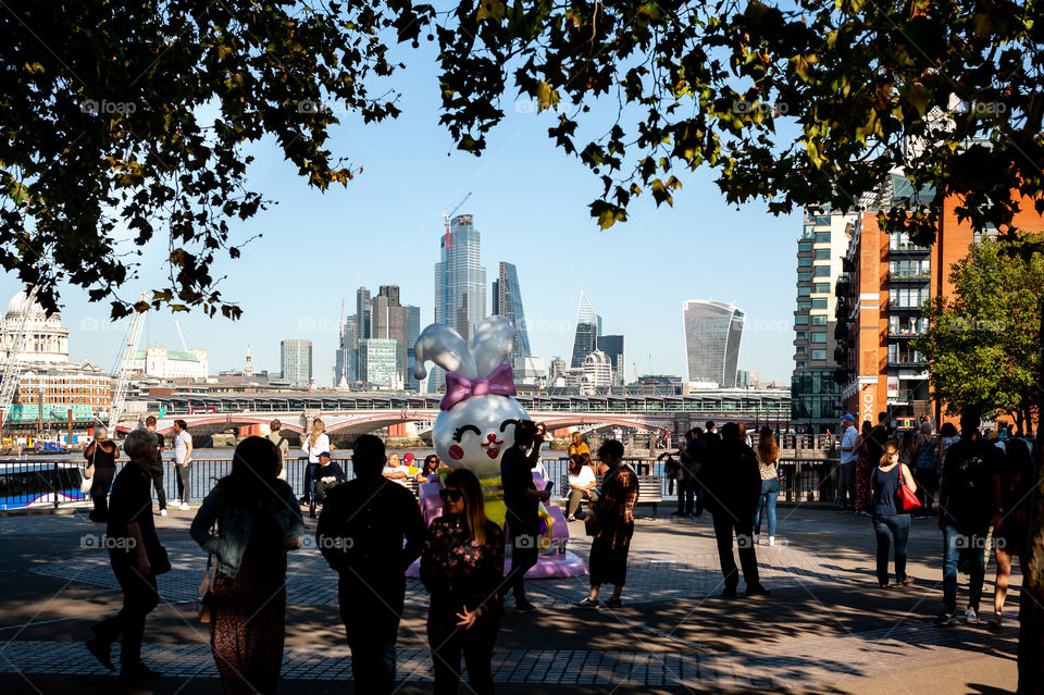 People on Queens Walk, riverside passage with a view at City of London financial district. London. UK.