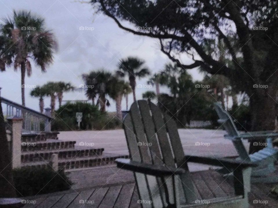 Empty chair caught in the beginning of a storm at the beach.
