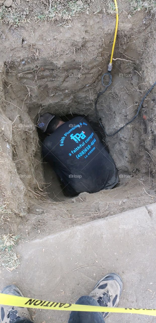 this is what hard work looks like. in a hole, fixing pipe