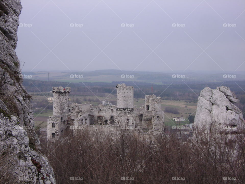 The ruins of a castle surrounded by rock formations. 