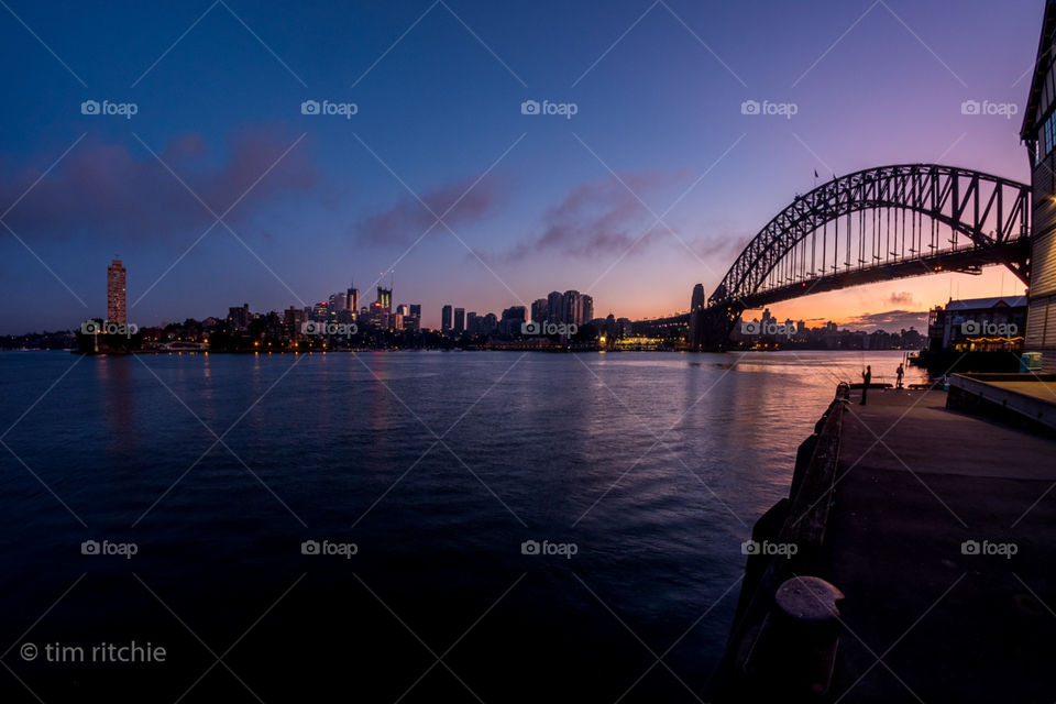 On the left (still in a night light) is Harry Seidler’s Blues Point Tower, then North Sydney in the centre of the pic. Move more to the dawn and you spot the Sydney Harbour Bridge and a couple of fishermen on Pier 2, Walsh Bay