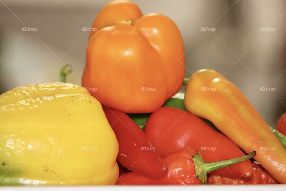 Orange sweet bell pepper capsicum among variety of coloured peppers