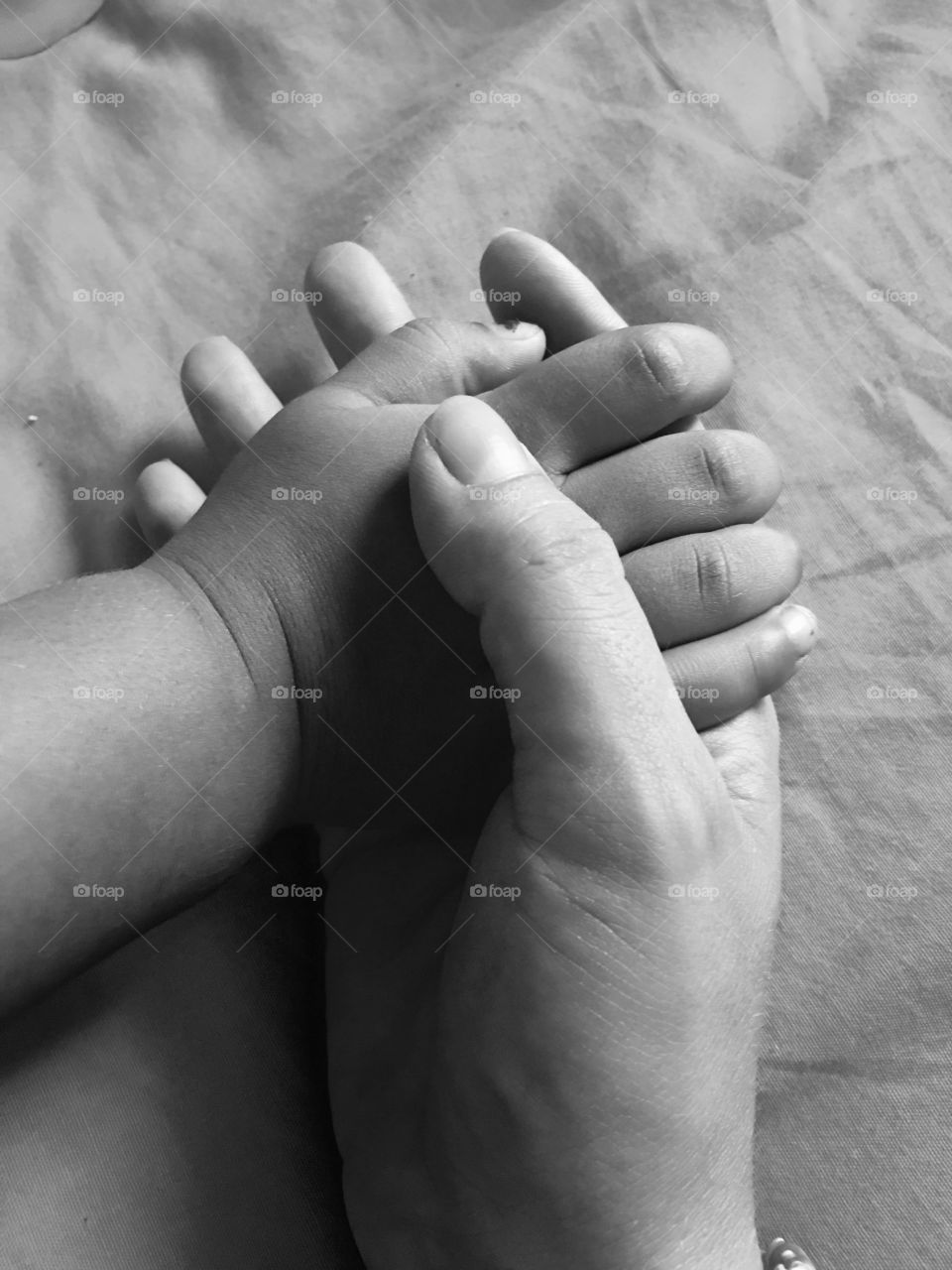 A mother holding her child's hand.