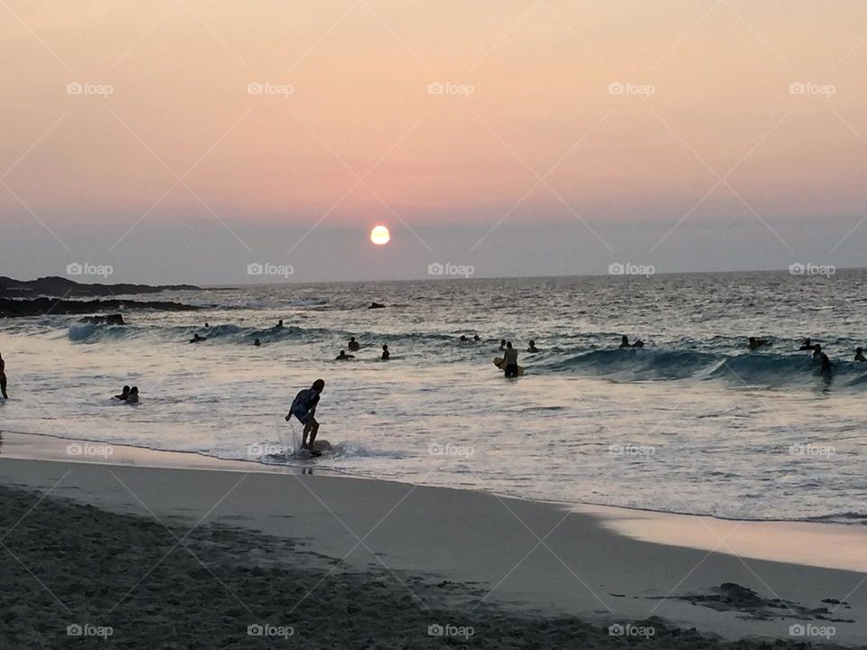 Last surf at sun set on a summer evening in Hawaii