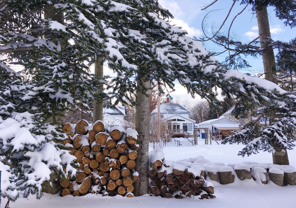 A woodpile is covered with snow in a winter neighbourhood 