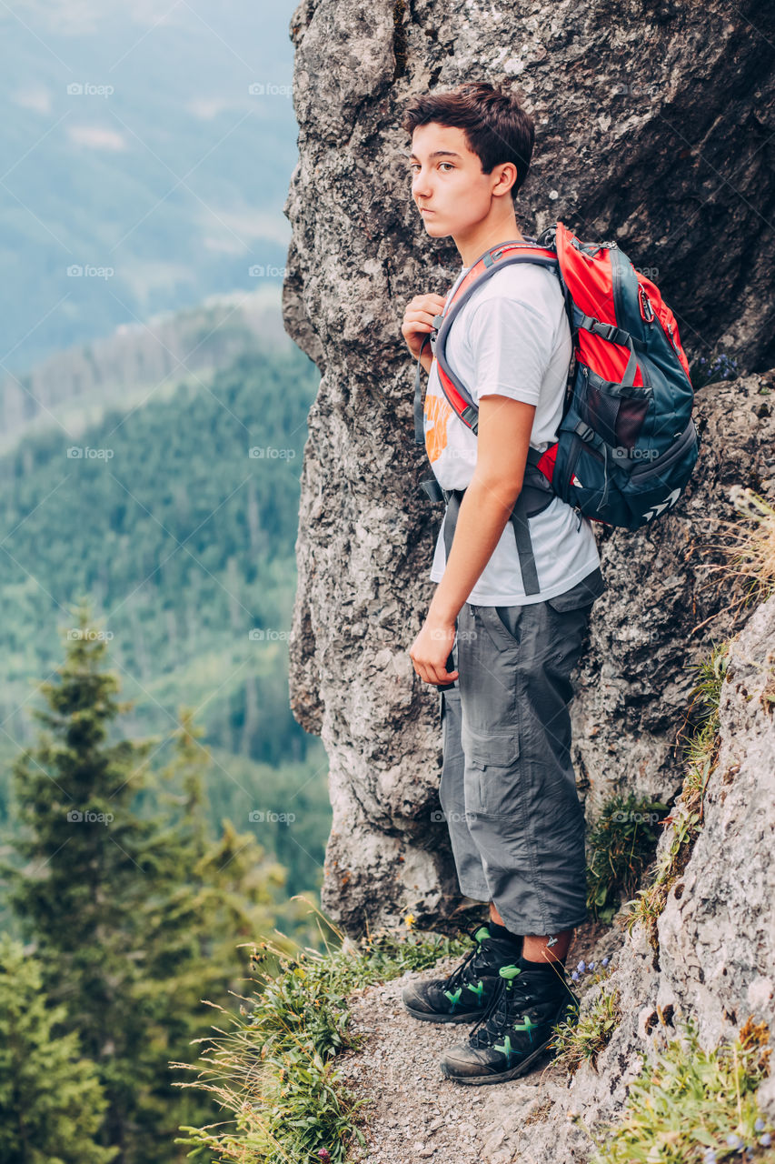 Teenager hiker boy standing mountain with backpack