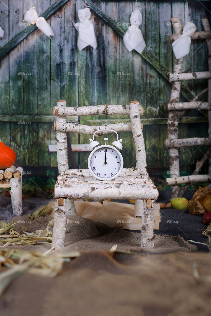 Alarm clock on a wooden bed. Halloween background.