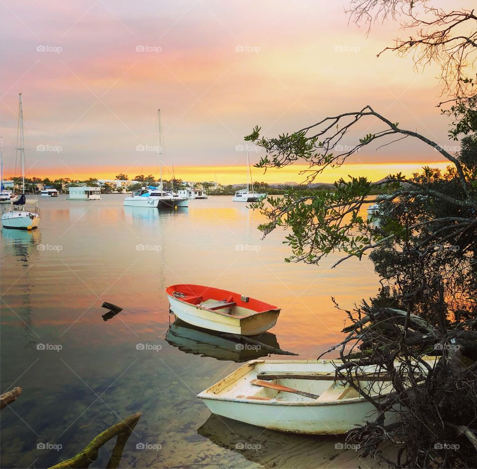 Pink sunset on the river with little boats