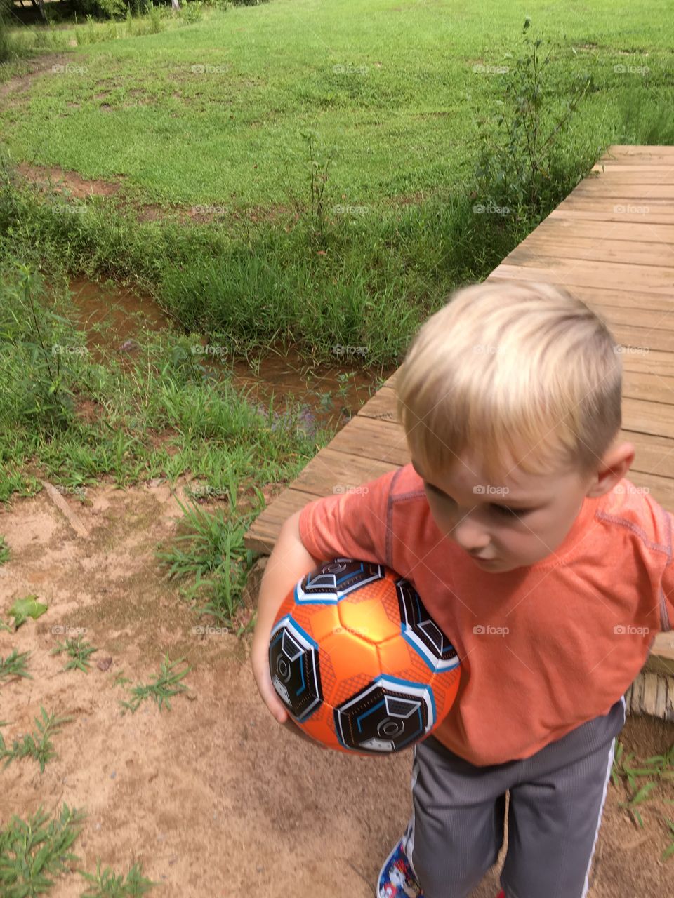 Happy toddler with a retrieved ball from the creek