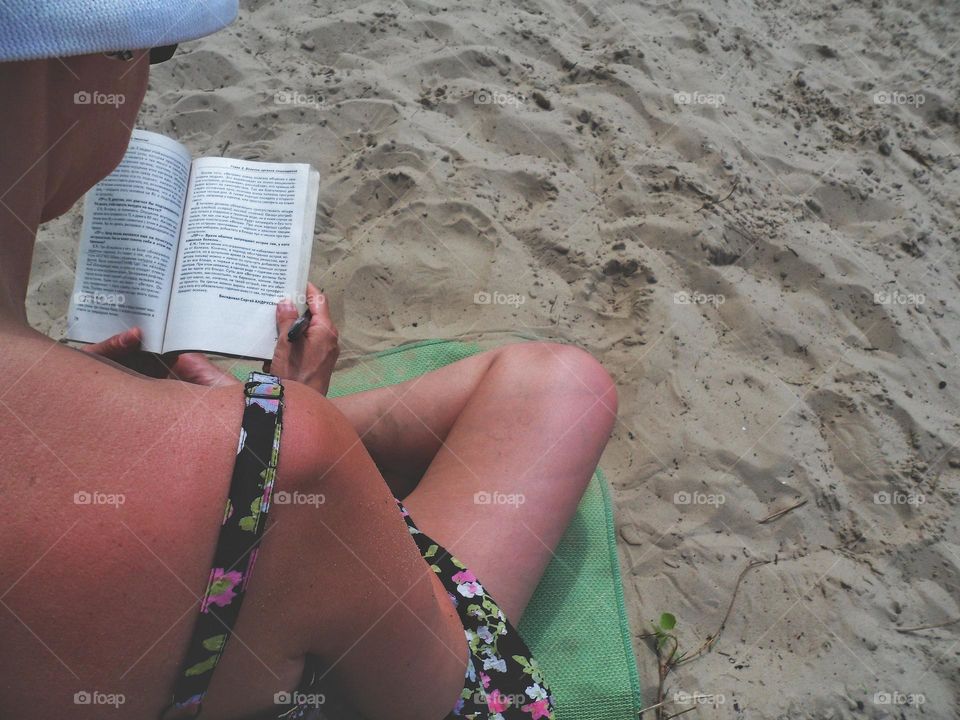 girl on the beach reading a book