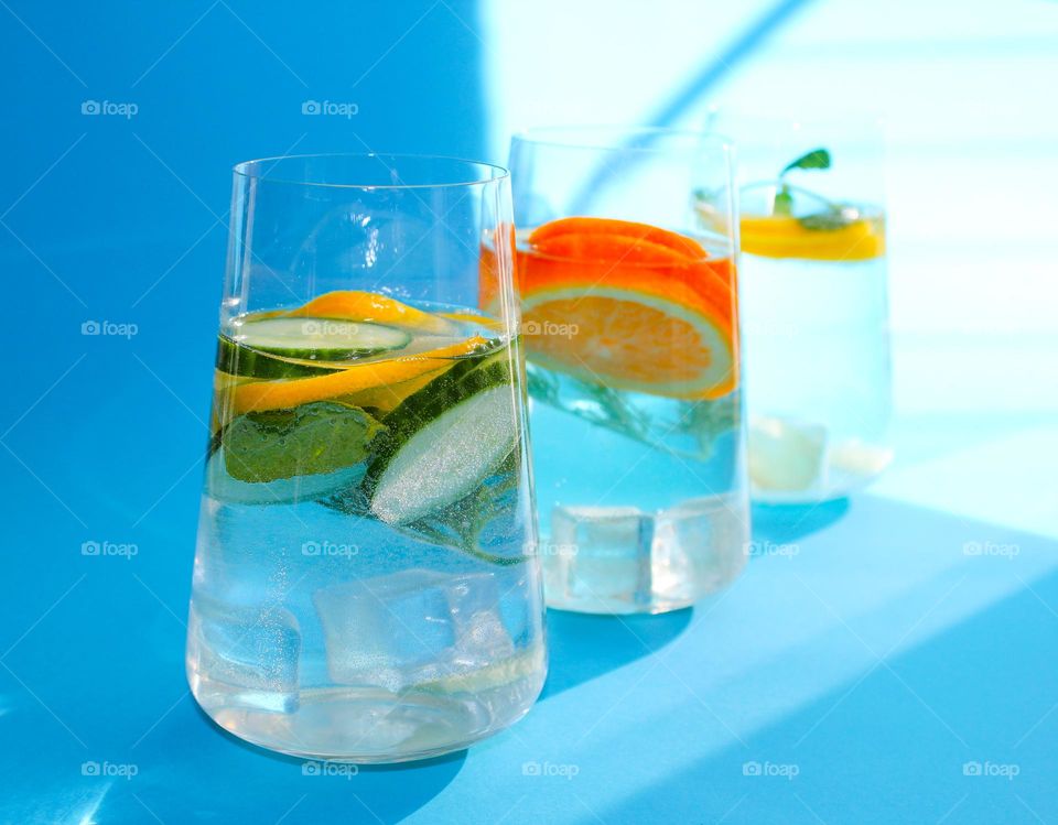 Three glasses of water with lemon, orange, cucumber, ginger and mint. The concept of a healthy lifestyle