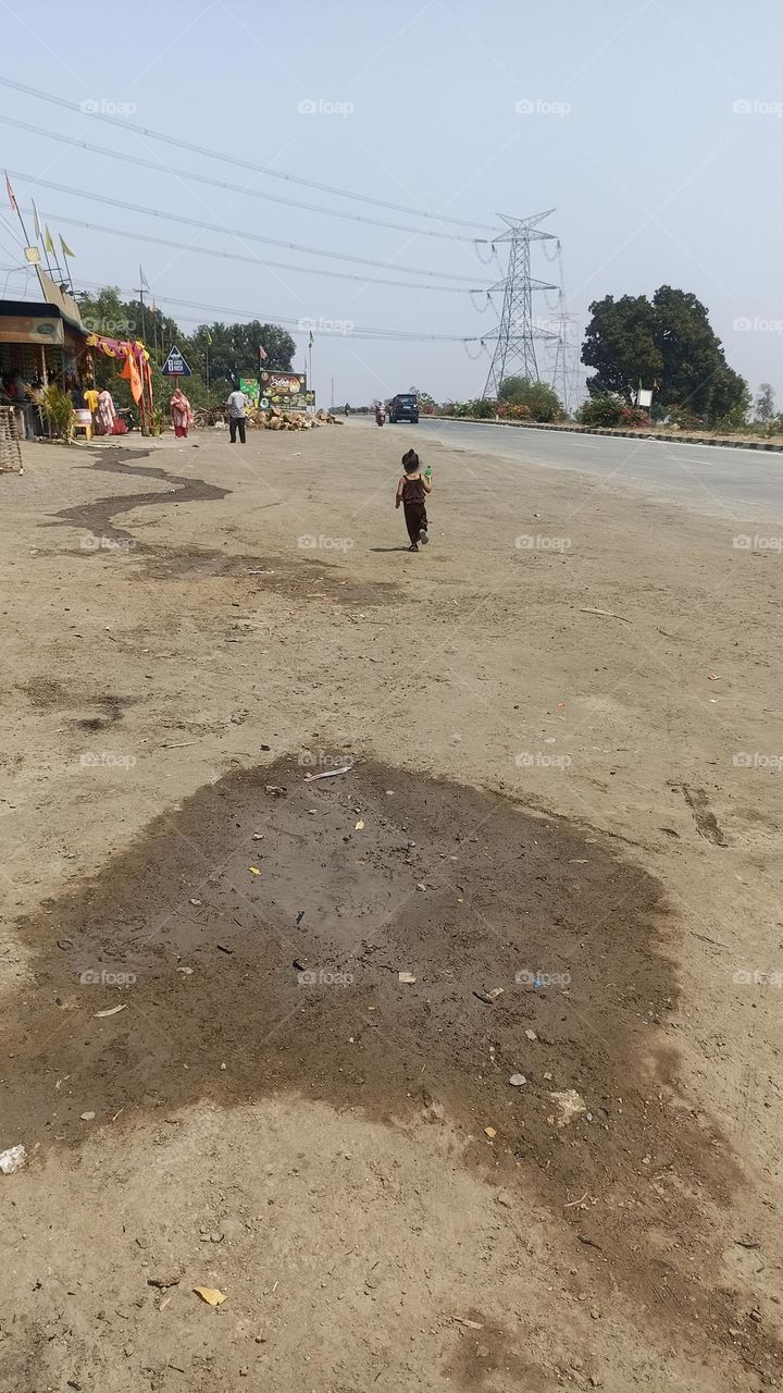 a child with a water bottle in its hand running towards it's parents