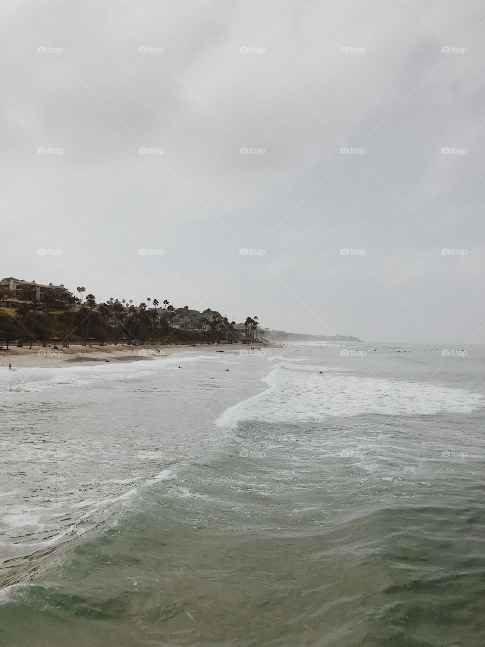 Foggy morning watching the small waves crash on the shore in the Pacific Ocean. 