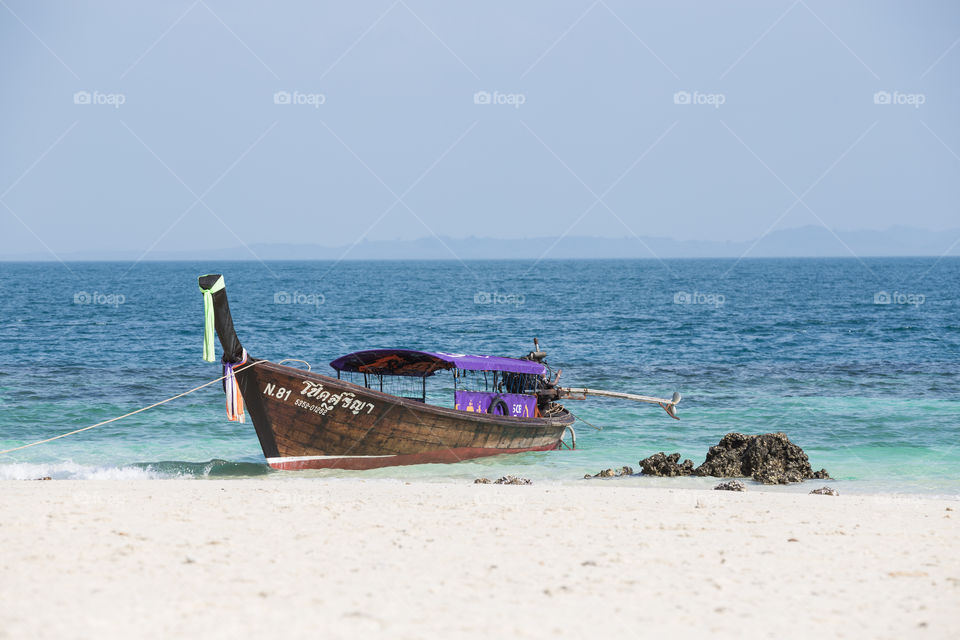 Longtail boat docking in the beach in Krabi Thailand 