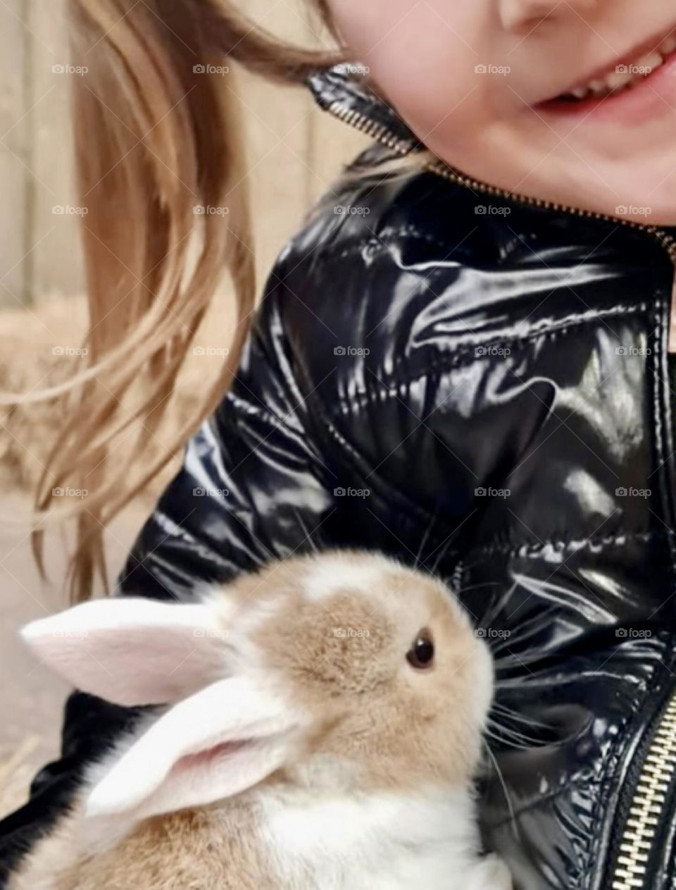 Young child holding a fluffy little bunny rabbit 