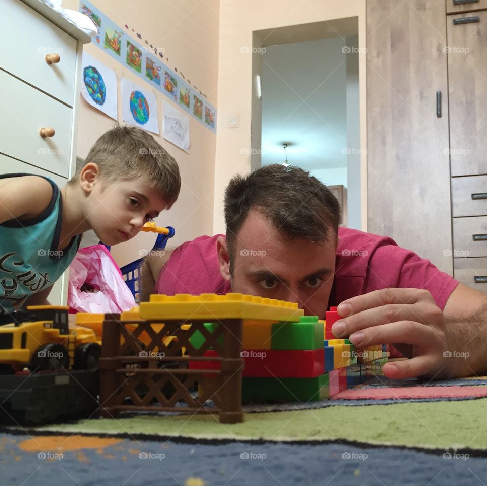 Father and son play with Lego 