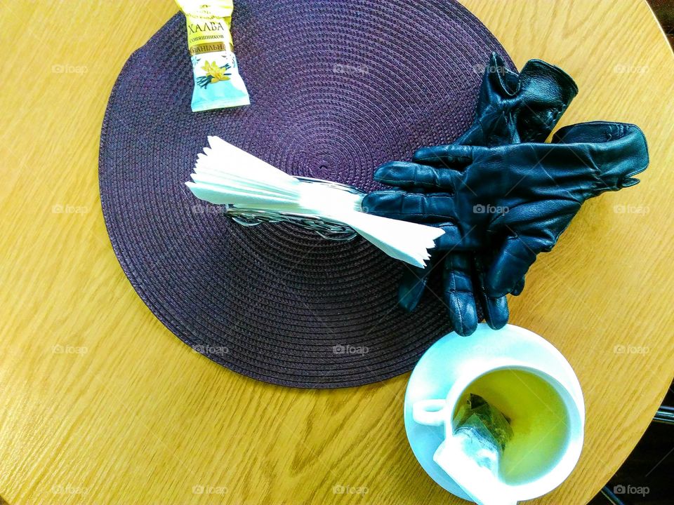 cup of green tea, gloves, wipes and paste on the table