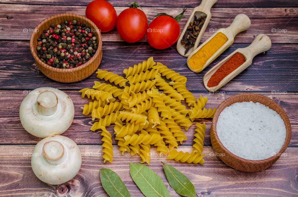 Raw pasta with ingredients and wooden accessories