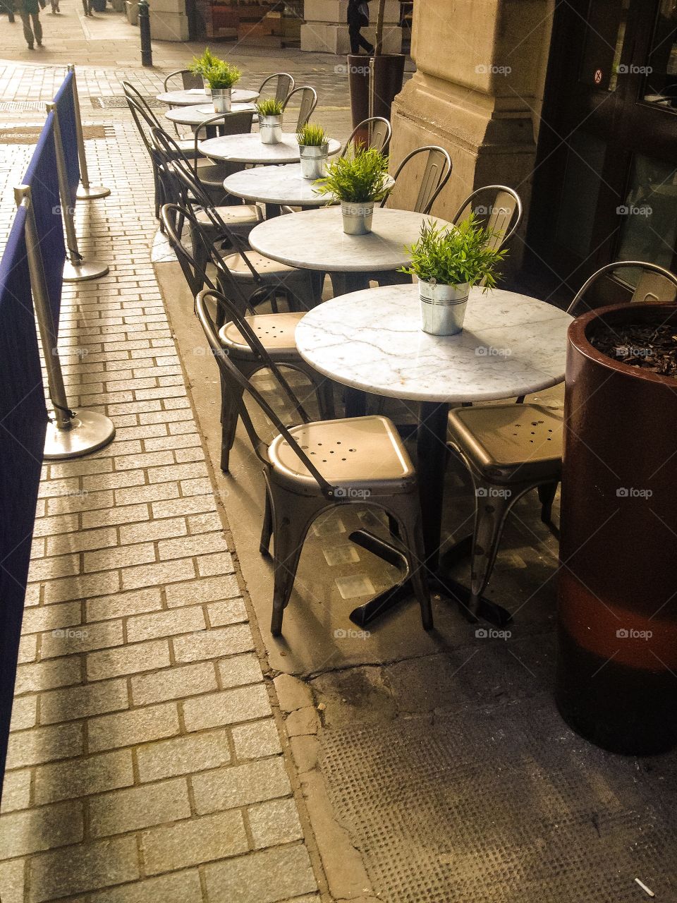 Empty chairs and table at sidewalk cafe